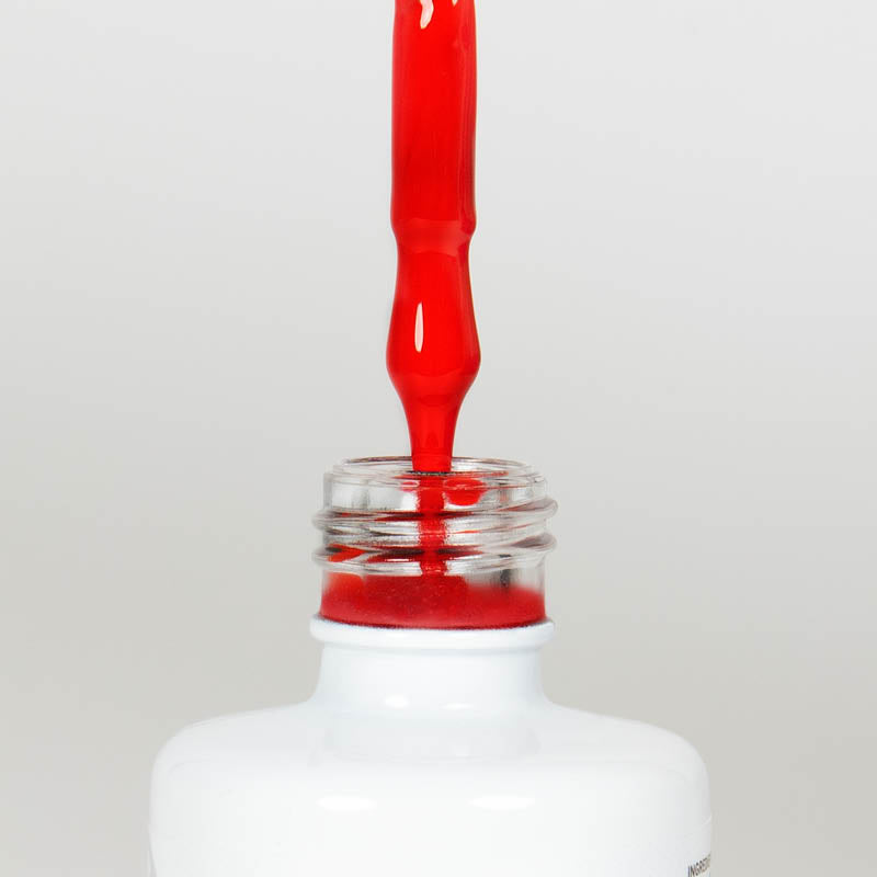 Nahaufnahme einer Longlife UV-Lack Scuderia Flasche. Die Farbe ist intensiv leuchtend Rot. Der UV-Lack tropft am Pinsel herunter.