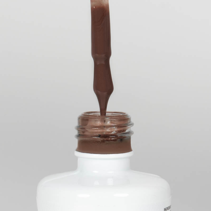 Nahaufnahme einer Longlife UV-Lack Slurry Flasche. Die Farbe ist dunkelbraun. Der UV-Lack tropft am Pinsel herunter.