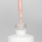 Nahaufnahme einer Longlife UV-Lack Soul Flasche. Die Farbe ist ein helles Nude mit leichtem Pinkstich. Der UV-Lack tropft am Pinsel herunter.