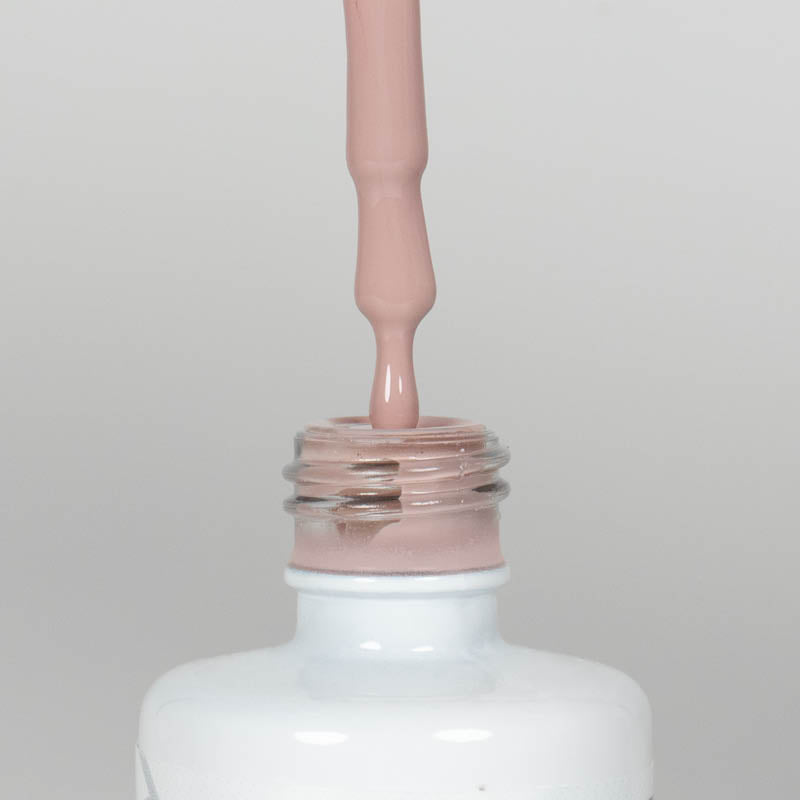 Nahaufnahme einer Longlife UV-Lack Spirit Flasche. Die Farbe ist ein helles Nude. Der UV-Lack tropft am Pinsel herunter.