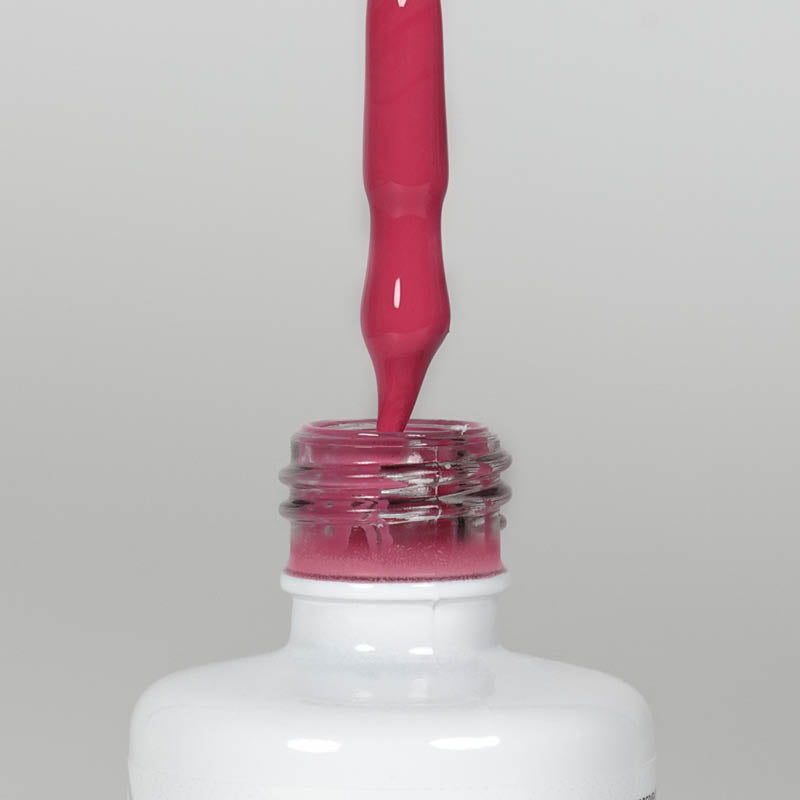 Nahaufnahme einer Longlife UV-Lack Strawberry Flasche. Die Farbe ist Pink mit leichtem Rotstich. Der UV-Lack tropft am Pinsel herunter.